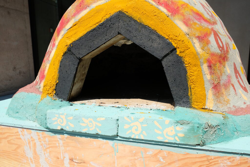 The finished cob oven was painted in some naturally made colors such as iron oxide for red and turmeric for yellow at Roe Studios Whatcom Community College.